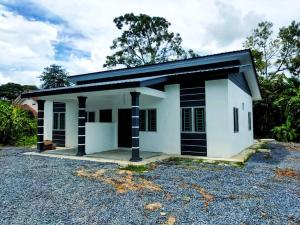 a small white house with black and white stripes at Homestay Triple S SAFINAH kangar in Kangar