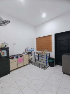 a room with a kitchen with a table and a counter at Homestay Triple S SAFINAH kangar in Kangar