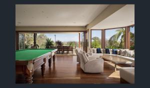 ein Wohnzimmer mit Billardtisch und Stühlen in der Unterkunft Rancho del Cielo in Carbrook
