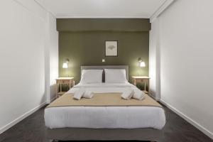 Un dormitorio con una cama grande con dos mesas. en OneZeroTwo by Zoia Living, en Atenas