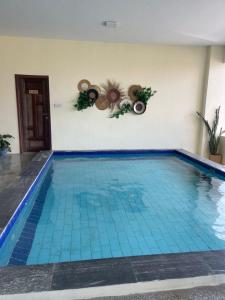 a swimming pool with blue tiles in a building at SEA-VIEW 3-Bedroom/5-BEDS-APT in Dar es Salaam