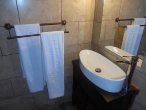 een badkamer met 2 handdoeken en een wastafel bij Parklands Shade Hotel in Nairobi