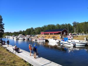 a group of people standing on a dock near boats at Färjas Brygga in Söråker