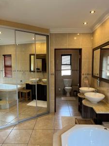 a large bathroom with two sinks and two toilets at Villa on 8 Pecanwood in Hartbeespoort