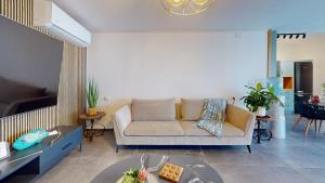 a living room with a couch and a table at זוהר בגליל-מיני וילה עם בריכה וג'קוזי בעין יעקב in ‘Ein Ya‘aqov