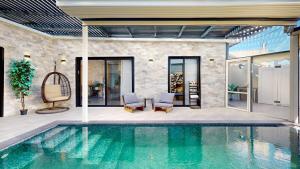 a swimming pool with two chairs and a table at זוהר בגליל-מיני וילה עם בריכה וג'קוזי בעין יעקב in ‘Ein Ya‘aqov +6 photos