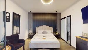 a bedroom with a white bed and a chair at זוהר בגליל-מיני וילה עם בריכה וג'קוזי בעין יעקב in ‘Ein Ya‘aqov