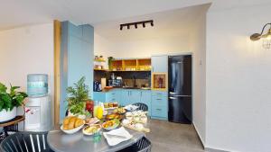 a kitchen with blue cabinets and a table with food on it at זוהר בגליל-מיני וילה עם בריכה וג'קוזי בעין יעקב in ‘Ein Ya‘aqov