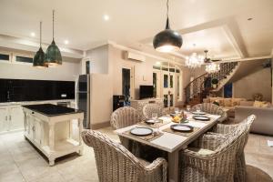 una cucina e un soggiorno con tavolo e sedie di Rose Villa Seminyak a Seminyak