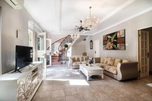 un soggiorno con un divano e una TV di Rose Villa Seminyak a Seminyak