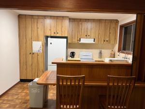 a kitchen with wooden cabinets and a table and chairs at Family Room in Two Story Home - R9 in Sydney +2 photos