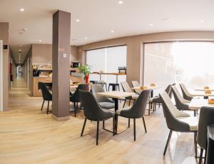 a restaurant with tables and chairs in a cafeteria at Hotel Golden Madrid in Madrid