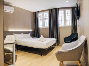 a bedroom with a bed and a desk and a chair at Hotel Golden Madrid in Madrid +86 photos