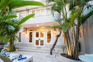 una casa con delle palme davanti di Rose Villa Seminyak a Seminyak