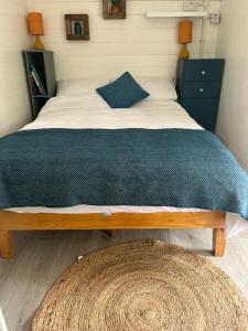 a bedroom with a bed with a blue and white comforter at Caban y Castell in Moffat