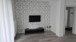 a living room with a tv on a wall at Casa Magurele 4 in Măgurele