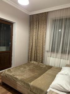 a bedroom with a large bed and a window at АПАРТАМЕНТ 124 у метро in Yerevan