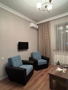 a living room with two chairs and a couch and a tv at АПАРТАМЕНТ 124 у метро in Yerevan