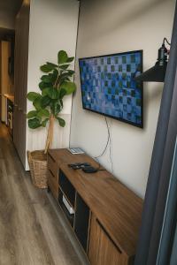 a living room with a flat screen tv on a wall at Menlyn Apartment - Studio in Pretoria