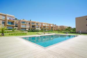 a swimming pool in front of a building at Ocean View Duplex & Golf, Taghazout Bay in Tamraght Ouzdar