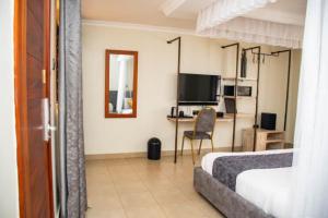 a hotel room with two beds and a desk at Distinction Gardens in Siaya
