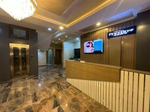 een hotellobby met een receptie en een televisie bij Prestine Apartments in Abuja