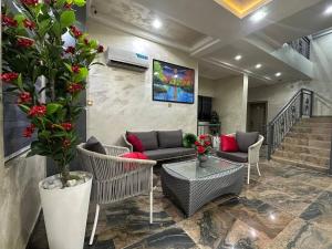 een woonkamer met banken en stoelen en een trap bij Prestine Apartments in Abuja