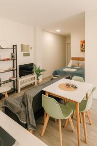 a living room with a table and chairs and a bed at Suite by Hawkins interior 1º A in Algeciras