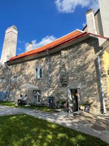 a stone building with two people sitting on a bench outside at Bishop's Residence in Tallinn