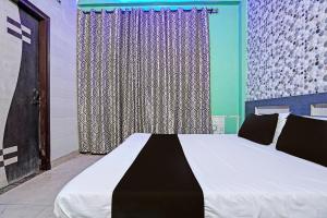 a bedroom with a large bed with a window at Hotel O Ginni in Rohtak