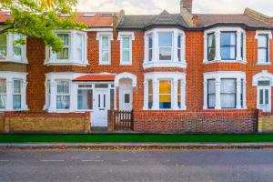 Casa de ladrillo rojo con puertas y ventanas blancas en K Suites - Ashford Road, en Londres