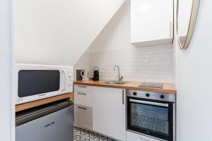 a small kitchen with a microwave and a stove at Bright Studio 3P – Close to Deauville Beach in Deauville