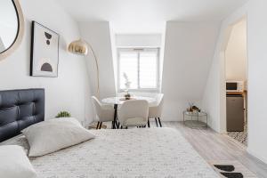 a bedroom with a bed and a table with chairs at Bright Studio 3P – Close to Deauville Beach in Deauville +2 photos