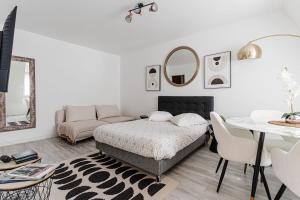 a bedroom with a bed and a table and a couch at Bright Studio 3P – Close to Deauville Beach in Deauville