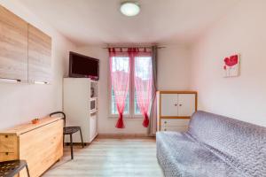 ein Wohnzimmer mit einer Couch und einem Fenster in der Unterkunft charmant Studio in Lamalou-les-Bains