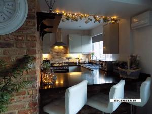 eine Küche mit weißen Stühlen und einer Arbeitsplatte in der Unterkunft Double Award Winning 1700's Grd 2 listed cottage near Stonehenge in Amesbury