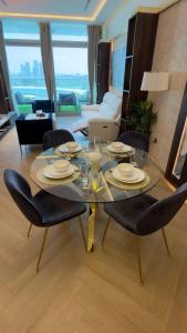 a glass table and chairs in a living room at Highend Azure Stay Palm Jumeirah in Dubai +29 photos