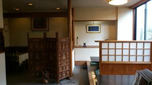 una habitación con una puerta y una mesa en una habitación en Yamaichi Bekkan, en Miyajima