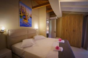 a bedroom with a large white bed with pink flowers on it at Rouda Bay Beach Hotel in Mikros Gialos