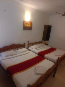 two twin beds in a room with a tv at Dreamy beach in Puducherry +25 photos