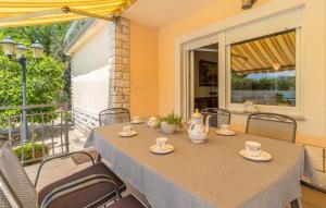 a table with cups and saucers on it on a patio at Villa Mary by Villas Guide in Jadranovo