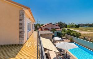a balcony of a house with a swimming pool and an umbrella at Villa Mary by Villas Guide in Jadranovo