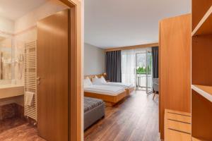 una habitación de hotel con una cama y un baño en Hotel Brenner - Stop & Go, en Vipiteno