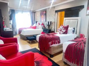 a bedroom with two beds with red and white blankets at Sintokha Guest House in Newcastle