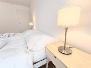 波普拉德Apartment Poprad - Tatra Elegant, Near High Tatras, Free Parking, Modern Stay的一间卧室配有两张床和一张桌子上的台灯。