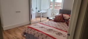 a bedroom with a bed and a mirror at Beautiful home feeling No 62 in Croydon