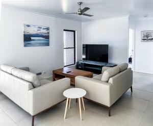 a living room with two couches and a tv at The Ranch 4brm,3bth,AC,Pool in Glenella
