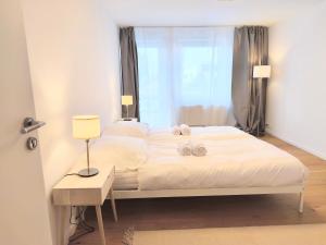 波普拉德Apartment Poprad - Tatra Elegant, Near High Tatras, Free Parking, Modern Stay的卧室里有一张铺着白色床单的床和一扇窗户