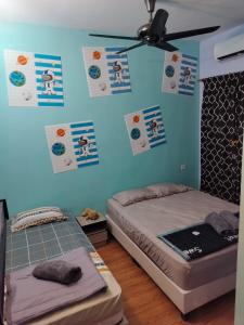 two beds in a room with posters on the wall at Idea Homestay 1 in Chemor +3 photos