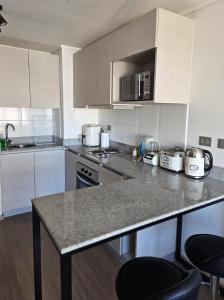 コンセプシオンにあるConcepción centro departamento acogedorの白いキャビネットとカウンタートップを備えたキッチン
